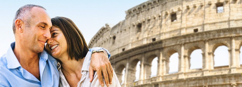 A couple in each others arms smiling in front of the Colosseum — Central Quest, elite dating agency