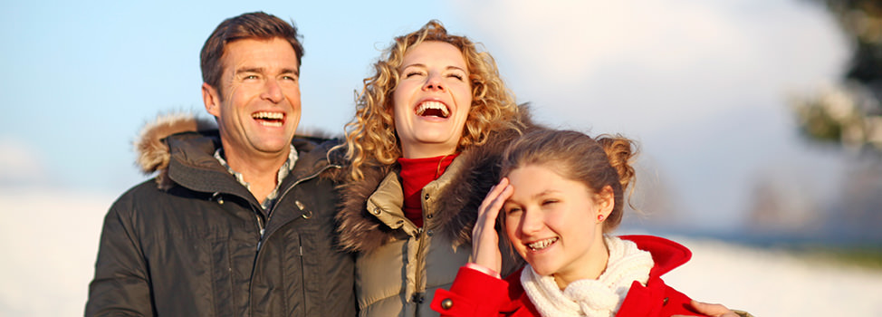 A couple with a teenage daughter smile whilst walking in the outdoors — Central Quest, elite dating agency for divorced men with children